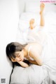 A woman laying on a bed with her head on a pillow.