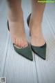 A close up of a woman's feet wearing green shoes.