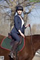 A woman riding on the back of a brown horse.