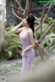 A woman in a purple dress posing for a picture.