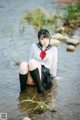 A woman in a school uniform is sitting in the water.