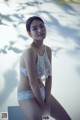 A woman in a white lingerie posing for a picture.