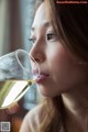 A woman is drinking a glass of white wine.