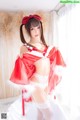 A woman in a red and white lingerie posing for a picture.