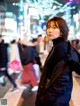 A woman standing in the middle of a busy city street.