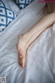 A woman laying on a bed with her feet up.