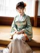 A woman in a green and white kimono sitting on a couch.